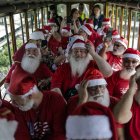 Hombres disfrazados de Papá Noel abordan el turístico "tranvía de Santa Tereza", en Río de Janeiro (Brasil)