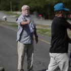 Un hombre dispara un arma hacia un manifestante en medio de un bloqueo de docentes en la vía Panamericana hoy, en Chame (Panamá).