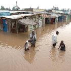 La gente camina por una calle inundada en una ciudad cerca de Nairobi, la capital de Kenia.