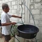 Una persona se aprovisiona de agua ante el anuncio de suspender el servicio de manera imprevista en la península de Santa Elena.