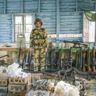Un soldado de la milicia Fuerza para la Defensa del Pueblo Chin posa con un arsenal.