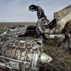 Residentes locales recogen chatarra de un avión de combate estrellado en la región de Kharkiv, Ucrania.