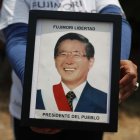 Fotografía de archivo en la que se registró a un seguidor del expresidente peruano Alberto Fujimori al sostener en sus manos una foto del exmandatario, en Lima (Perú).