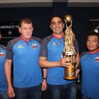 El argentino Martín Mandra posa con su cuerpo técnico y uno de los títulos que ganó con los chullas