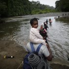 Migrantes cruzan el río Turquesa, en Darién (Panamá)