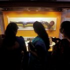 Un grupo de personas observa una de las piezas que han sido recuperadas y expuestas en un museo.