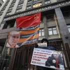 Moscú. Un hombre lleva una pancarta (“Putin es nuestro líder”), frente a la sede de la Federación de Rusia.