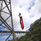 Héctor Chacón, mayor de los Bomberos Municipales, desciende hoy del puente ferroviario Las Vacas durante el acto de entrega de regalos a niñas y niños de escasos recursos del asentamiento Jesús de la Esperanza, en Ciudad de Guatemala (Guatemala).
