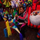 Labor. Una persona en México trabaja en un local donde se elaboran y se venden las típicas piñatas.