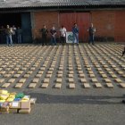 Un agente de la Policía Metropolitana de Cali al custodiar un cargamento de cocaína incautado en un contenedor de fruta, en la zona de carga del aereropuerto Rodrigo Bonilla Aragón, en Cali (Colombia).