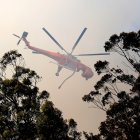 Un helicóptero de los bomberos sobrevuela un incendio forestal en Australia..
