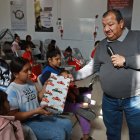El pastor Juan Fierro (d) reparte regalos a migrantes que pasan la Navidad en el albergue "El buen samaritano", el 24 de diciembre de 2023, en Ciudad Juárez Chihuahua (México).