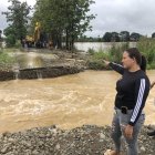Moradores observan el lugar donde la creciente del río Las Juntas se llevó un tramo de la carretera.