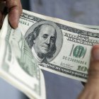 MANOS CONTANDO DINERO O BILLETES DE CIEN DÓLARES |