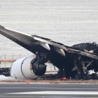 Tokio. Investigadores aeronáuticos inspeccionan los restos del avión incendiado en el aeropuerto de Haneda.