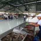 1. Mercado. Los comerciantes regularizados esperan impacientes recibir a los clientes que llegan poco.
