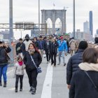 Varias personas caminando por el puente de Brooklyn sin vendedores a la vista en Nueva York.