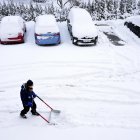 Después de la fuerte nevada de la noche, un hombre trabaja con una pala de nieve para quitar la nieve de las plazas de aparcamiento de un edificio residencial en Estocolmo, Suecia, este 5 de enero de 2024.