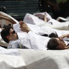 Los protestantes se cubrieron dentro de grandes plásticos blancos que representan bolsas mortuorias,