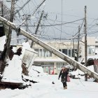 Suzu. Unas personas caminan bajo líneas eléctricas caídas en esta ciudad japonesa, afectada por el terremoto del 1 de enero de 2024.