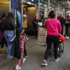 Personas con bolsas de pertenencias y cochecitos abandonan el hotel Row NYC.