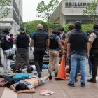 Policías detienen hoy a presuntos delincuentes a pocas cuadras de la sede del canal de televisión TC, donde encapuchados armados ingresaron y sometieron a su personal durante una transmisión en vivo, en Guayaquil (Ecuador).