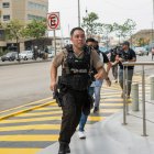 Policías persiguen hoy a un presunto delincuente a pocas cuadras de la sede del canal de televisión TC, donde encapuchados armados ingresaron y sometieron a su personal durante una transmisión en vivo, en Guayaquil