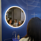 Personas observan hoy el espejo de Baracoda, que usa la IA generativa para aumentar la confianza de los usuarios y su estado de ánimo con mensajes positivos y meditaciones, en la feria tecnológica CES 2024 en Las Vegas, Nevada