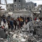 Los palestinos buscan personas desaparecidas bajo los escombros de los edificios destruidos tras los ataques aéreos israelíes, en Khan Yunis, al sur de la Franja de Gaza, el 12 de enero de 2024.
