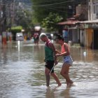 Habitantes transitan hoy por una calle inundada tras las lluvias de los últimos dos días, en el municipio de Duque de Caxias, en la región Baixada Fluminense, área metropolitana de Río de Janeiro (Brasil).
