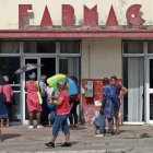 AME1047. LA HABANA (CUBA), 20/01/2024.- Personas esperan afuera de una farmacia, el 19 de enero de 2024, en La Habana (Cuba). Asegurarse suficientes almohadillas femeninas (toallas sanitarias o compresas) para el período menstrual se ha convertido en un verdadero dolor de cabeza para cada vez más cubanas en los últimos meses. Con la persistente crisis que azota al país, más de tres millones de cubanas tienen que "inventar" cada mes ante la escasez de este producto de primera necesidad, que ha desaparecido de las farmacias estatales y se encuentra solamente a elevados precios en tiendas en divisa y negocios de revendedores. EFE/ Ernesto Mastrascusa