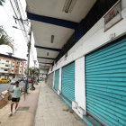 Comercio. Un ciudadano camina por la acera de una calle principal de Quevedo, junto a una serie de locales que permanecen cerrados, por alquilar o vender.