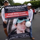 Familiares de Guillermo Marroquín muestran hoy un cartel con su retrato durante una marcha.