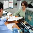 FUNCIONARIO DEL SRI ATIENDE A UNA MUJER CONTRIBUYENTE.