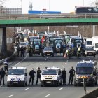 Agentes de policía vigilan decenas de tractores que participan en una manifestación en la autopista A15 cerca de Argenteuil, al norte de París, Francia, este lunes 29 de enero de 2024.