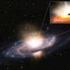 Vista lateral de una galaxia con brazos espirales de estrellas azules brillantes separadas por bandas oscuras de polvo interestelar.