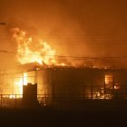 Una casa en llamas por un incendio que comenzó en la reserva natural del lago Peñuelas y ha llegado hasta las zonas urbanas en Viña del Mar.
