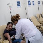 Una trabajadora de la salud revisa a una paciente sospechosa de dengue hoy, en el Centro de Atención de Dengue de la Policlínica Rodolpho Rocco, en el barrio Del Castilho, en Río de Janeiro (Brasil).