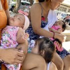 Madres filipinas y sus bebes en la entrada de un centro de salud.