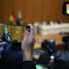 Una mujer graba con un teléfono al presidente de Bolivia Luis Arce durante la promulgación de la ley para elecciones judiciales este 6 de febrero de 2024, en la "Casa Grande" en La Paz (Bolivia).