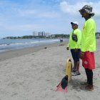 Dos salvavidas vigilan a los escasos bañistas en un sector de la playa de General Villamil.