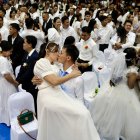 La pareja de novios Reynaldo Pingol y Maricel se besan durante una boda masiva el día de San Valentín en la ciudad de Bacoor.