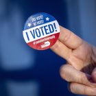 Una persona muestra la calcomanía de "Yo voté" después de ejercer su voto en Miami, Florida (EE.UU.).