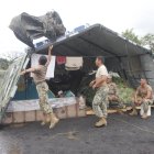 Personal de tropa coloca plásticos en las carpas del campamento para evitar mojarse con las constantes precipitaciones.