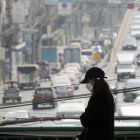 Una persona que lleva una máscara protectora camina mientras la fuerte contaminación del aire por partículas finas envuelve el cielo de Bangkok, Tailandia, el 15 de febrero de 2024.