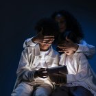 Una par de niños son contralados por una persona mayor, para evitar que sigan vinculados con un dispositivo electrónico.