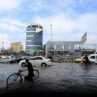 Trabajadores en una calle inundada durante un fuerte aguacero en Peshawar, Pakistán, el 19 de febrero de 2024.