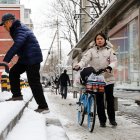La gente espera un autobús en la calle después de una Nevada en Beijing, China, 21 de febrero de 2024.