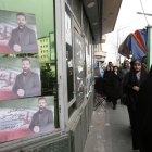 Mujeres iraníes con velo caminan junto a carteles de campaña electoral de candidatos parlamentarios durante el primer día de las campañas electorales