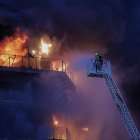 Bomberos trabajan en el incendio declarado sobre las cinco y media de esta tarde en un quinto piso de un edificio de viviendas de Valencia que ha afectado totalmente al inmueble y se ha propagado a otro anexo.